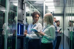 two women are working in a data center with rows of server racks