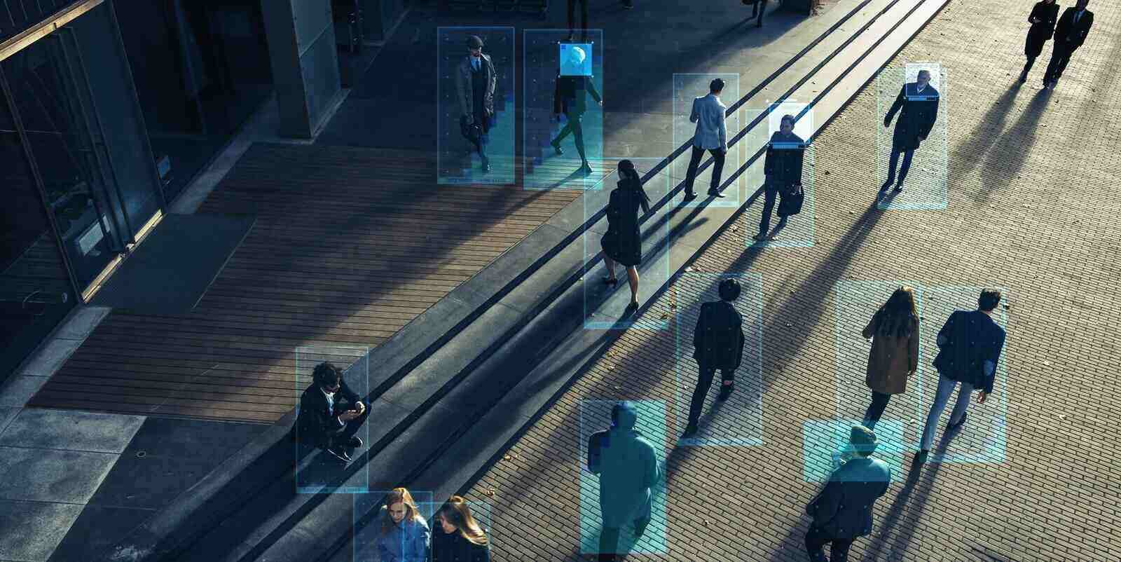 elevated security camera surveillance footage of a crowd of people walking on busy urban city streets